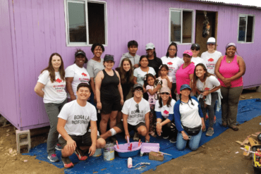 group of students painting a house