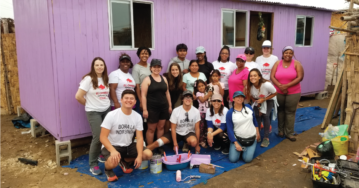 group of students painting a house