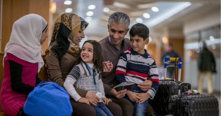 a family with three children traveling with luggage
