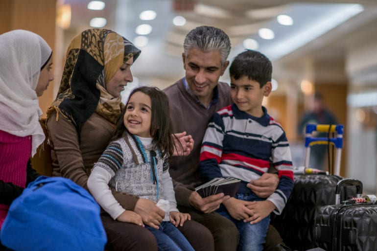 a family with three children traveling with luggage