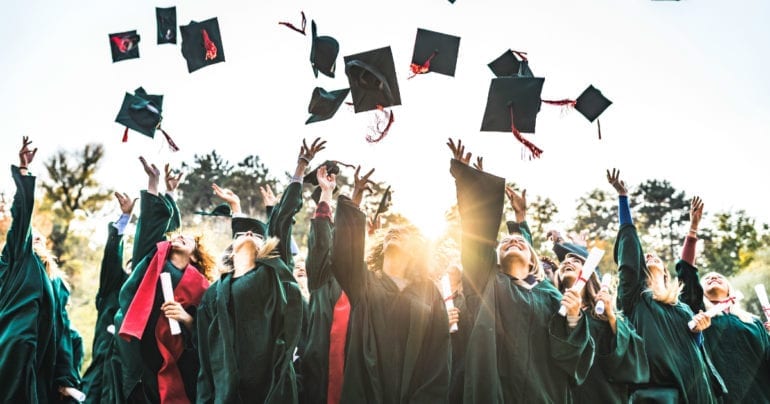 recent graduates throwing caps in the air