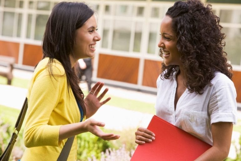 two women talking outdoors
