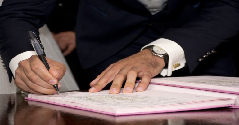 hands writing in a ledger