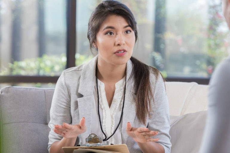 woman with clipboard listening to patient
