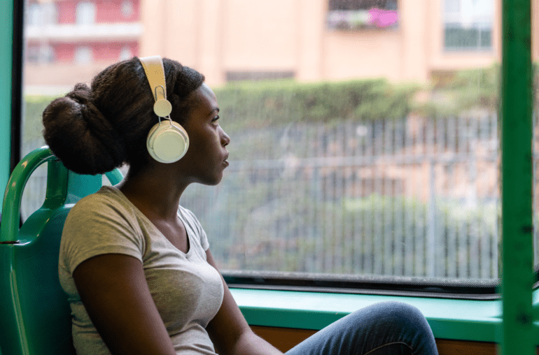 woman wearing headphones looking out the window