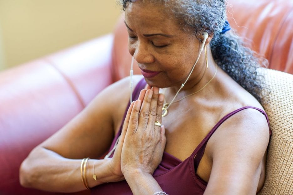 woman with ear bugs in doing yoga