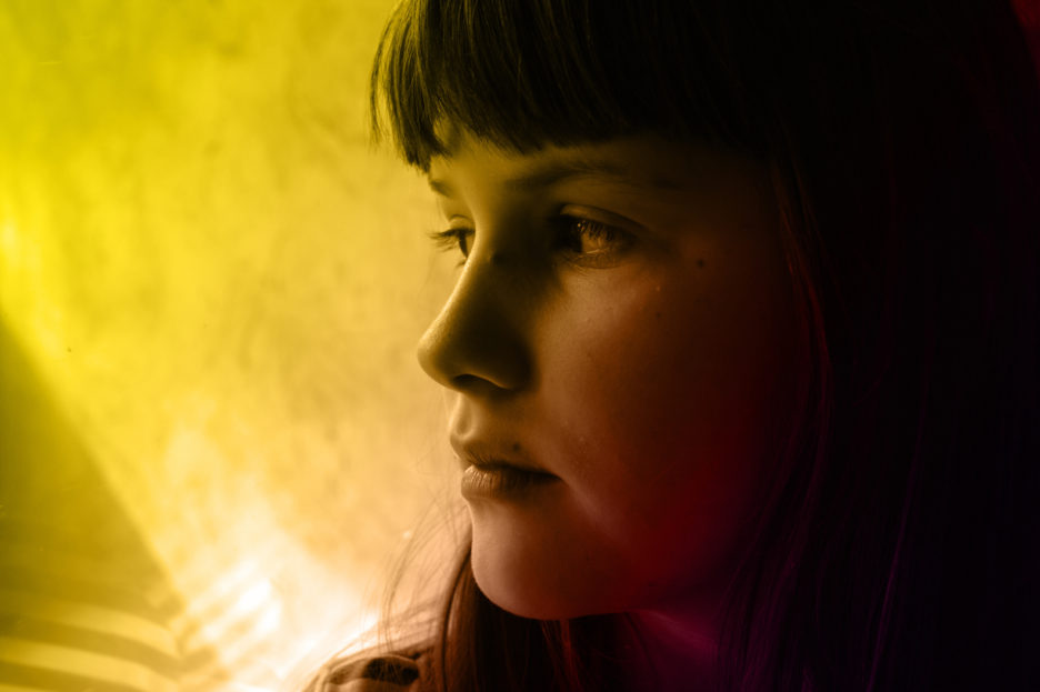 woman in a yellow toned image looking sad