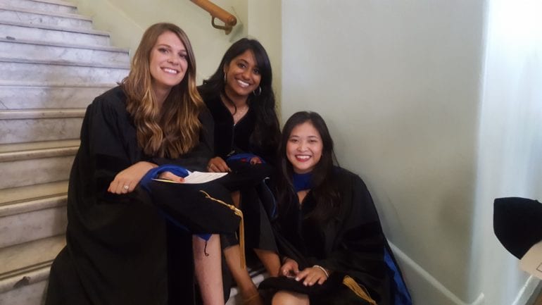 three female students in graduation gowns