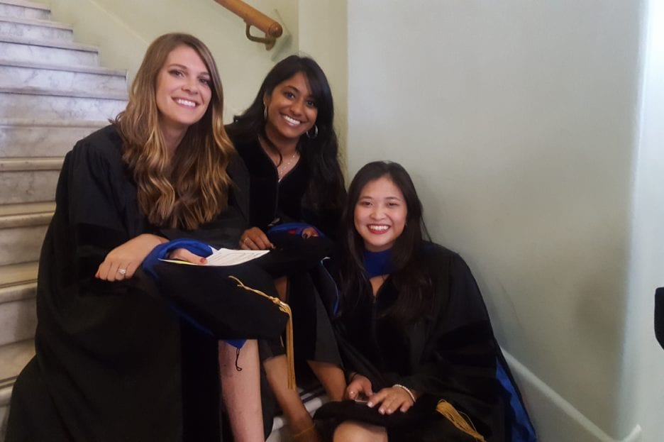 three female students in graduation gowns