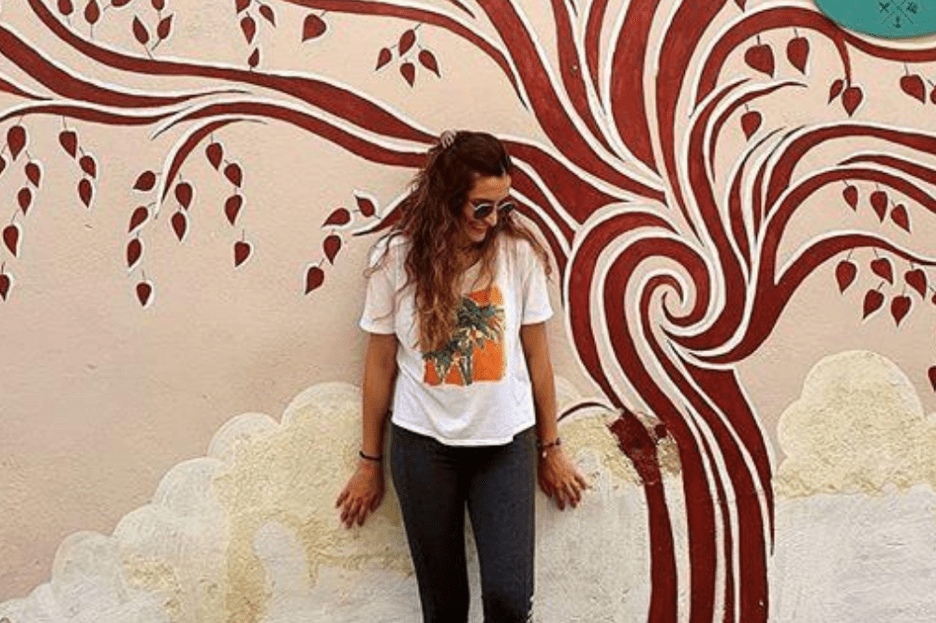 woman standing near artistically painted tree
