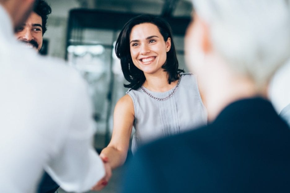 business psychologist pursuing her career and shaking hands in an interview