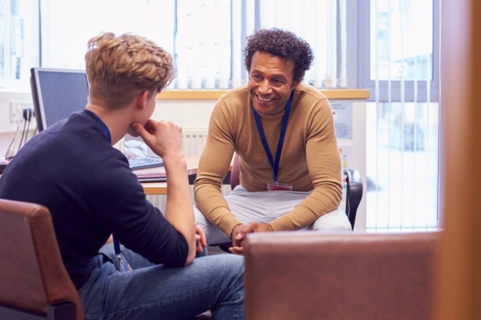 Adult man counseling younger boy