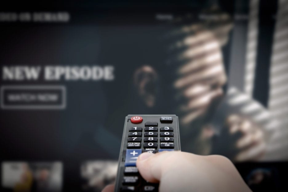 tv and remote control in hand