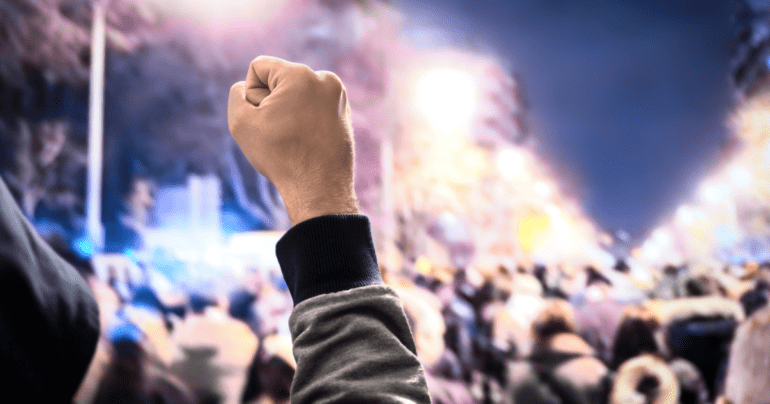 person with fist raised in the air