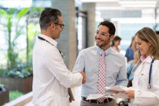 manager shaking hands with doctors