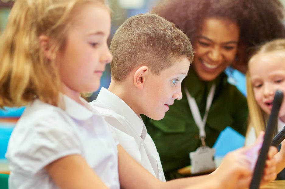 woman with three children using ipads