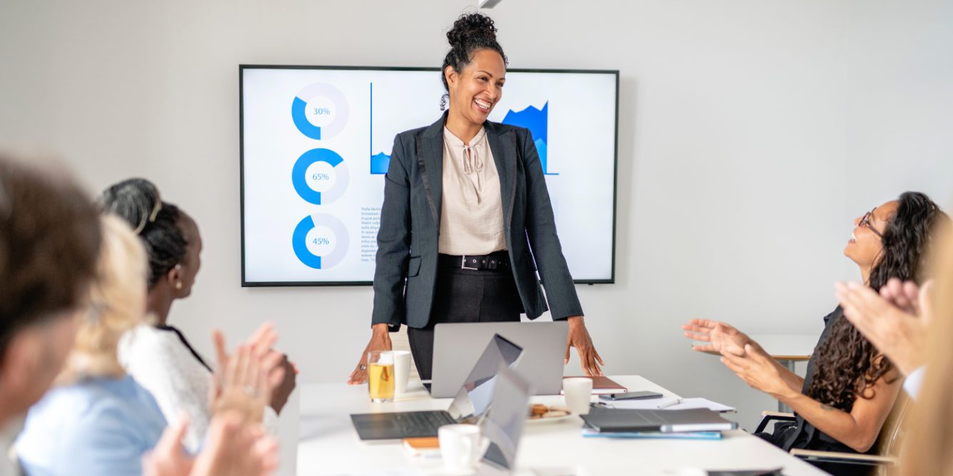 woman standing at head of table and presenting